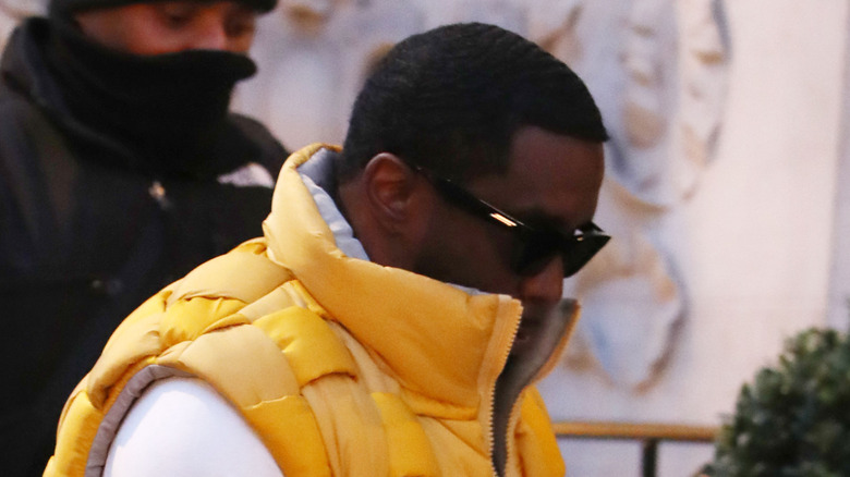 Diddy con la testa bassa in un gilet giallo