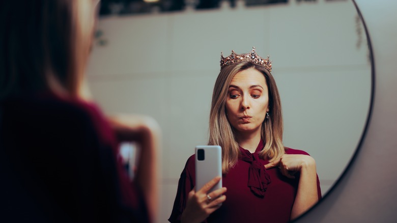 Donna narcisista che scatta selfie con corona