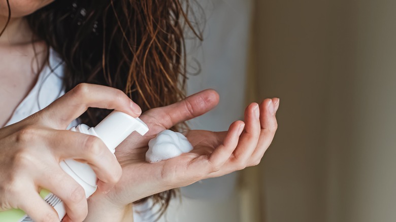 Donna che distribuisce la mousse nella mano