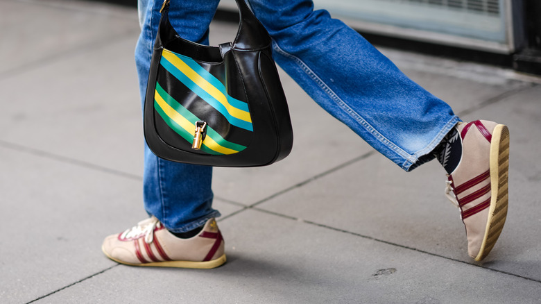 Borsa a righe colorate beige e sneakers rosse