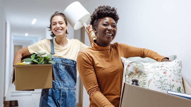 due donne che trasportano roba e ridono