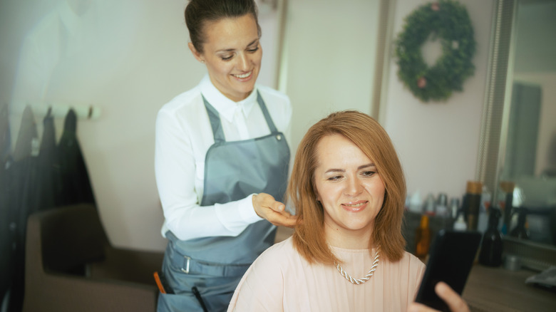 Donna che si fa tagliare i capelli maglione rosa