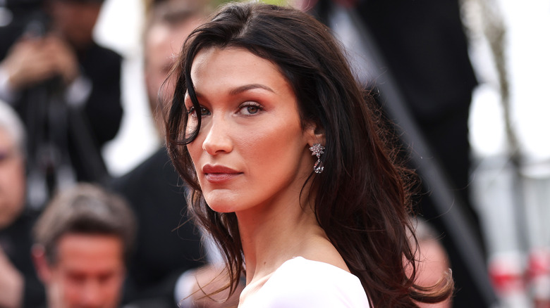 Bella Hadid che guarda oltre la spalla con i capelli sciolti e ondulati