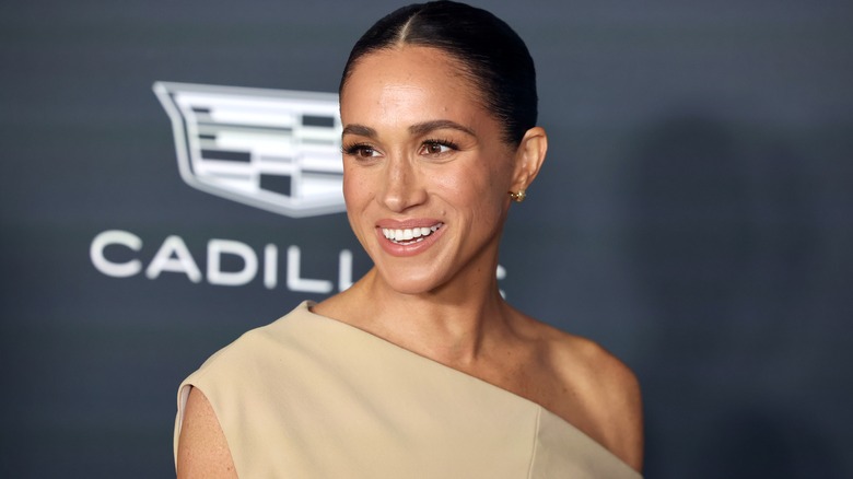 Meghan Markle indossa un abito beige monospalla