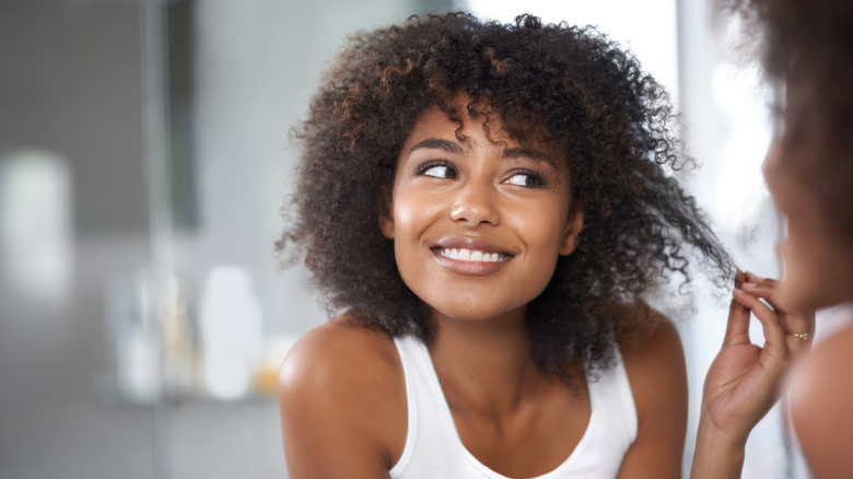 donna sorridente che si tira i riccioli