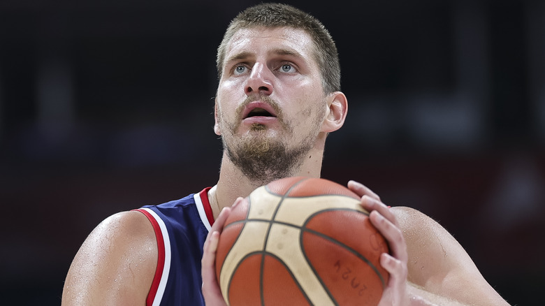 Nikola Jokic tiene in mano un pallone da basket