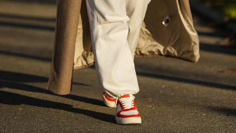 Donna che indossa scarpe da ginnastica rosse e bianche