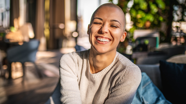 Donna sorridente con la testa rasata