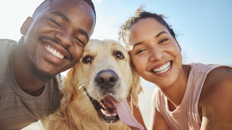 Coppia sorridente e felice con cane