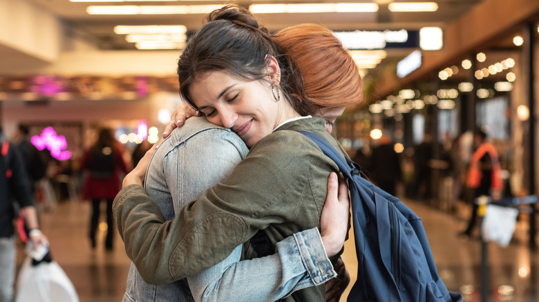 due donne che si abbracciano all'aeroporto