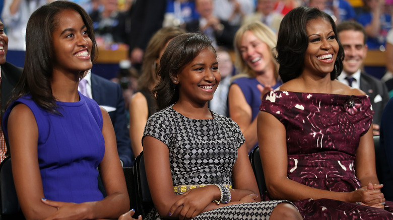 Malia, Sasha e Michelle Obama sorridono