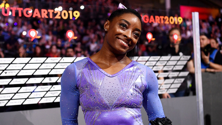 Simone Biles sorridente in body da ginnastica