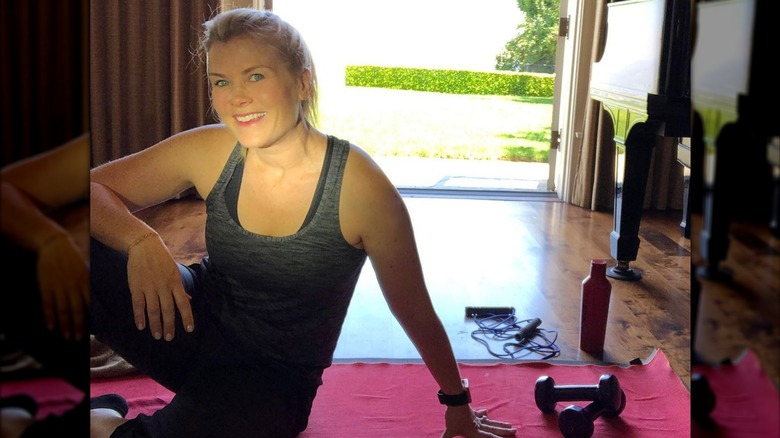 Alison Sweeney seduta sul pavimento con attrezzatura da allenamento