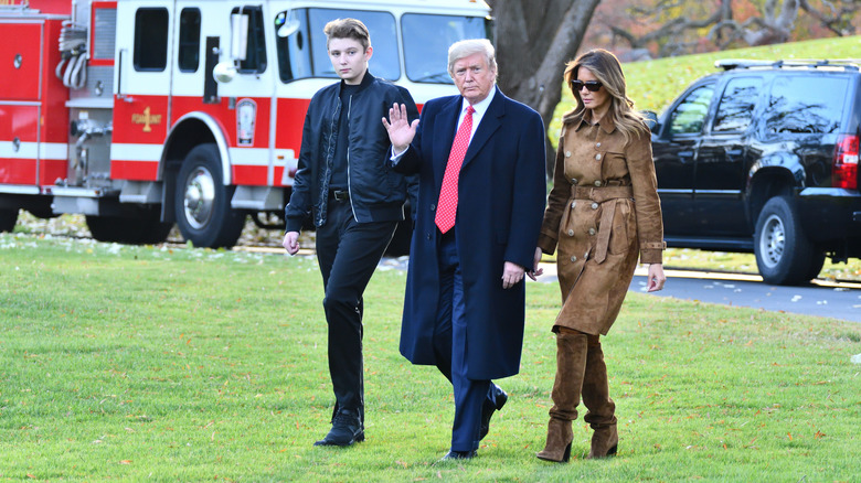 Barron, Donald e Melania Trump camminano