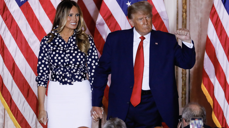 Donald e Melania Trump davanti alle bandiere