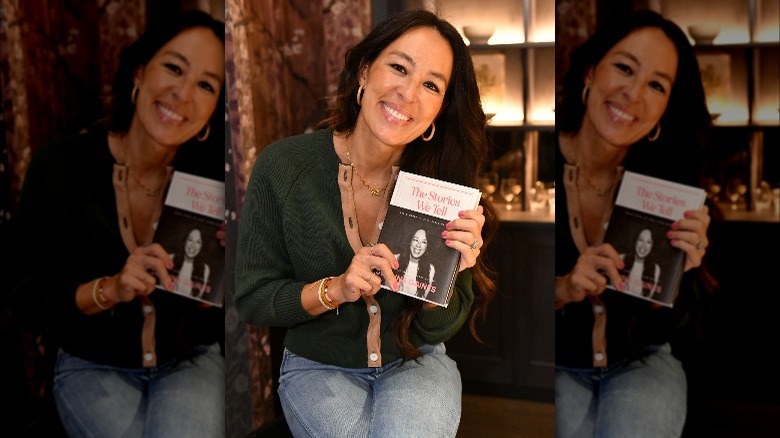 Joanna Gaines sorride tenendo in mano il suo libro