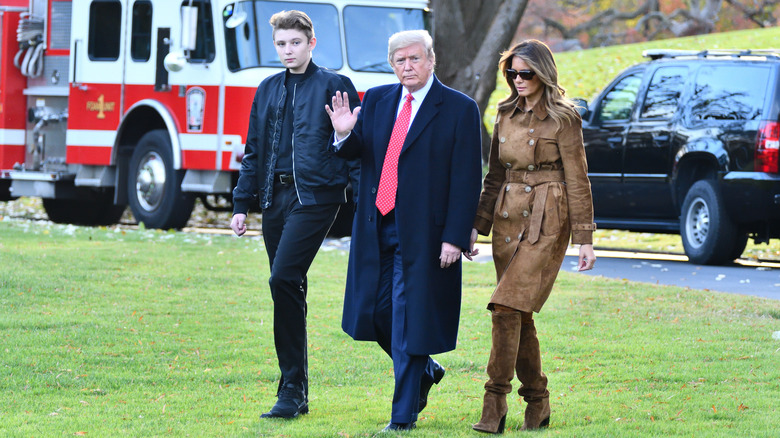 Barron, Donald e Melania Trump camminano