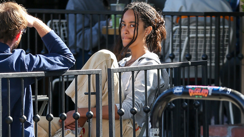 Malia Obama indossa una giacca blu e una camicia a quadri con colletto a righe