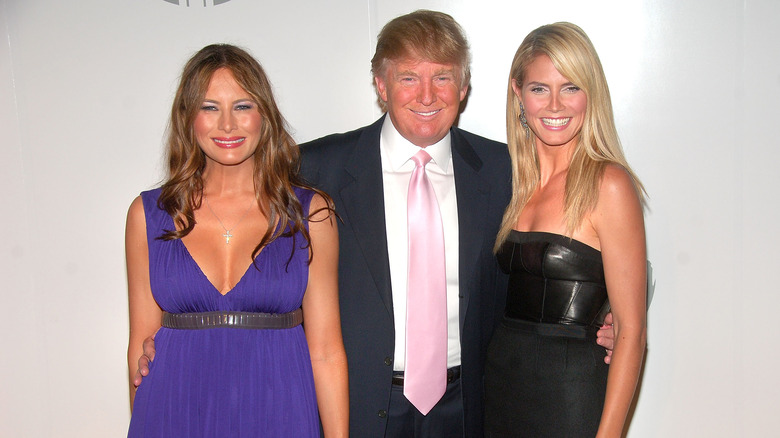 Donald Trump in piedi tra Melania Trump e Heidi Klum