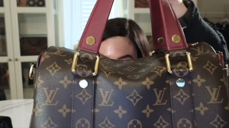 Claudia tiene in mano una borsa Louis Vuitton