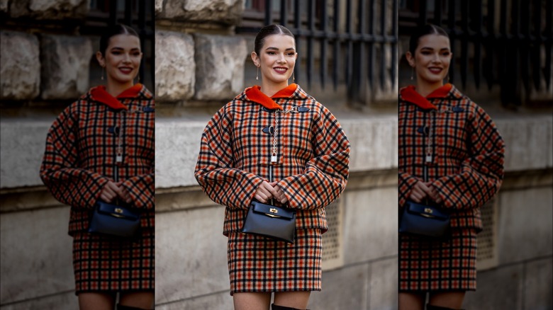 Donna che indossa cappotto e gonna a quadretti coordinati