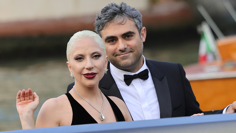 Lady Gaga indossa un abito scollato nero e una collana di diamanti con Michael Polansky che indossa uno smoking nero