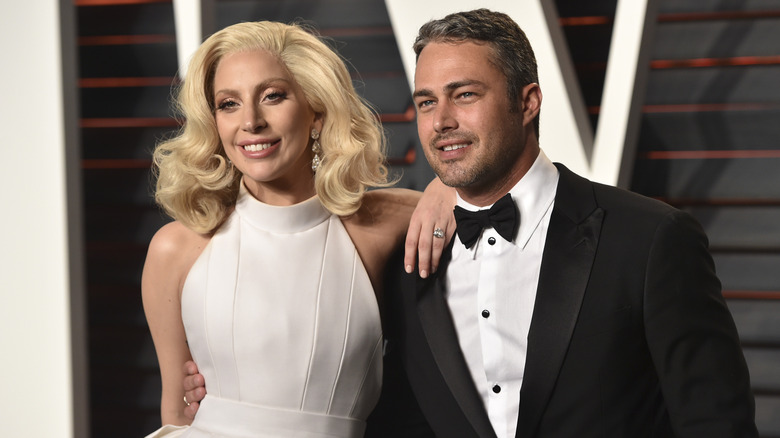 Lady Gaga indossa un abito bianco e un anello di diamanti mentre Taylor Kinney indossa uno smoking e un papillon