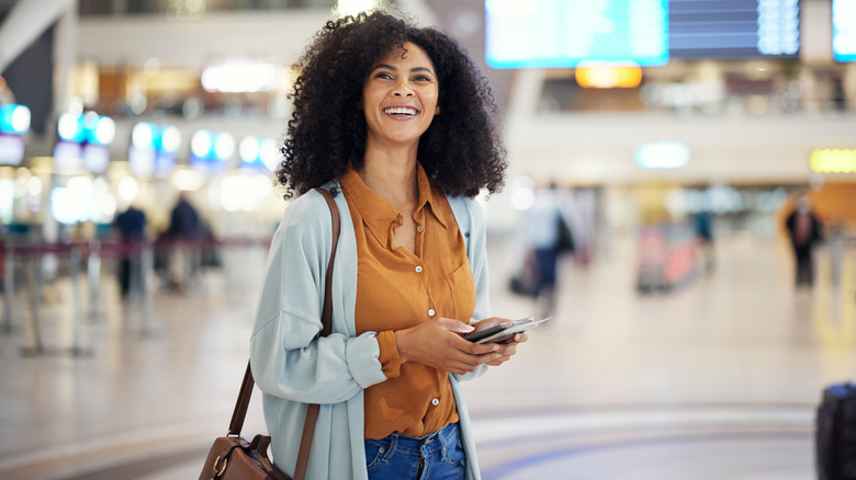 Donna all'aeroporto sorridente