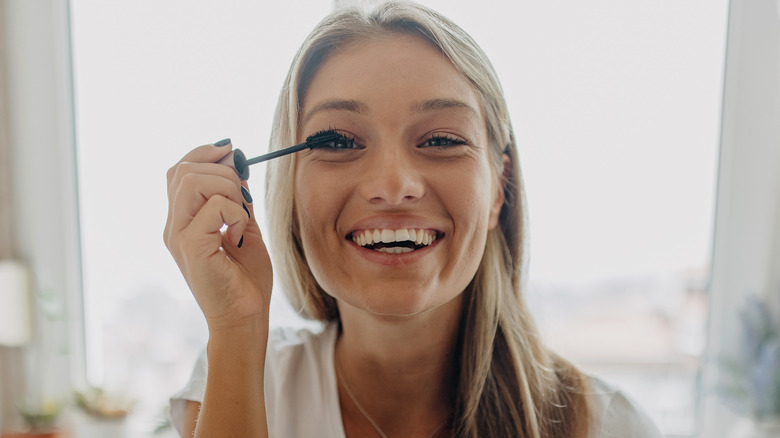 donna che applica uno strato di mascara