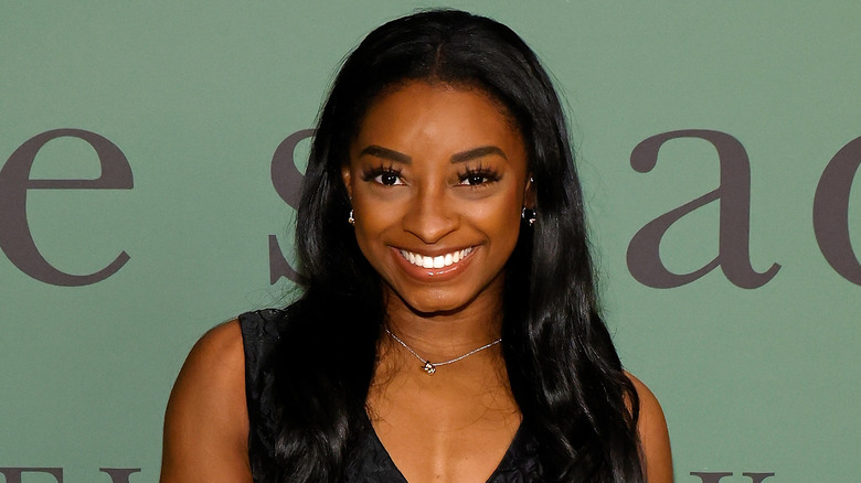 Simone Biles sorridente in abito nero