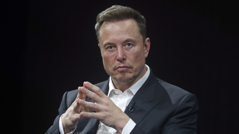 Elon Musk con le dita che si toccano durante la conferenza del 2023