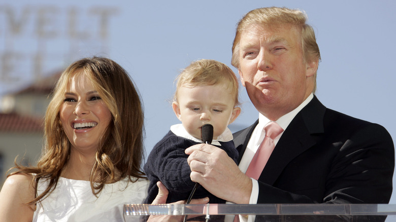 Melania Trump sorride, Donald Trump tiene in braccio Barron Trump