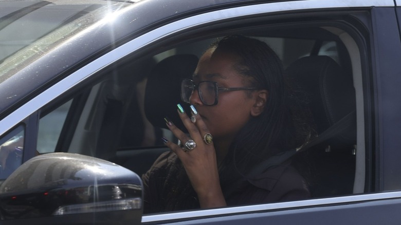 Sasha Obama è vista camminare verso la sua auto prima di partire, gustandosi una sigaretta sulla strada. Vestita con una camicia scura abbottonata infilata in pantaloncini di jeans azzurri a vita alta, completa il look con delle scarpe slip-on verdi, una grande borsa marrone e una vistosa collana rotonda. Scatto del 13/09/24