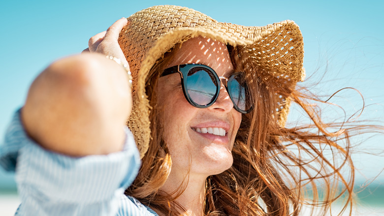 Donna che indossa cappello da sole e occhiali da sole