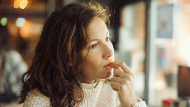 donna che si mangia le unghie al bar