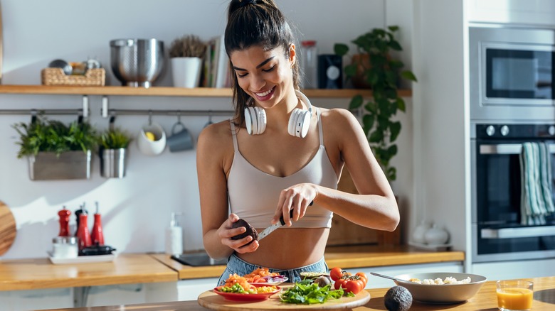 Donna sorridente che prepara un pasto sano