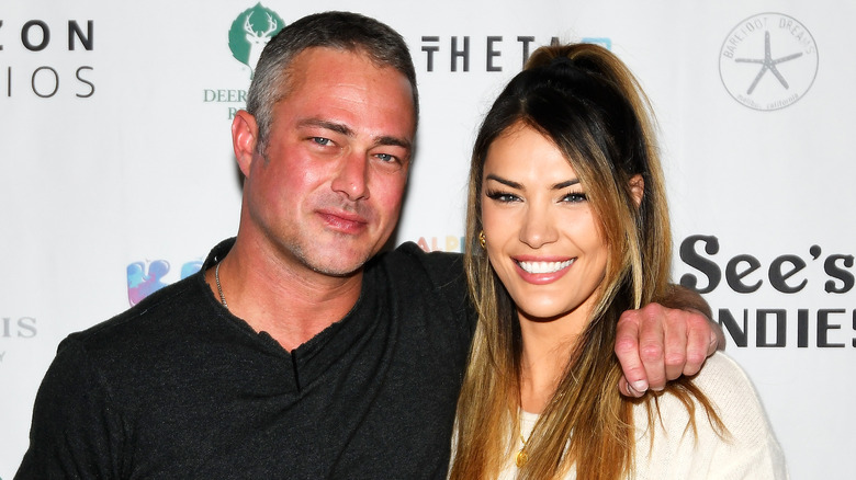 Taylor Kinney e Ashley Cruger sorridono