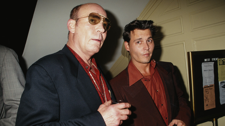 L'autore Hunter S. Thompson indossa una giacca nera e una camicia rossa con Johnny Depp che indossa una giacca marrone e una camicia arancione bruciata