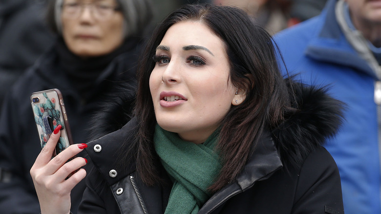 Laura Loomer con in mano il telefono