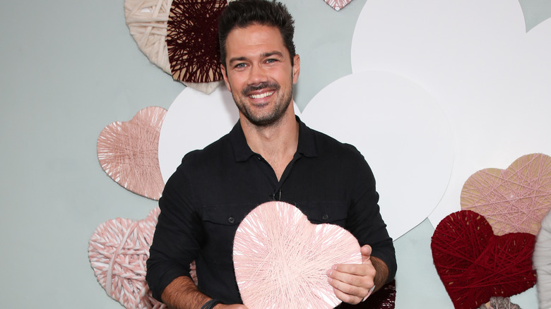 Ryan Paevey tiene in mano un cuore di carta decorata 