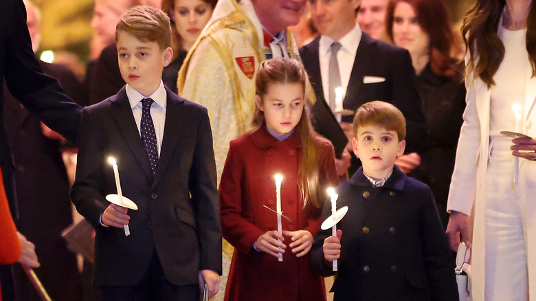 Il principe George, la principessa Charlotte e il principe Louis mentre tengono le candele