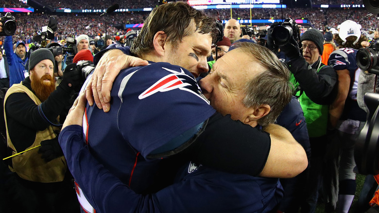 Bill Belichick e Tom Brady si abbracciano sul campo di calcio