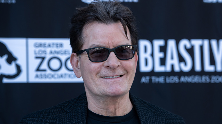 Charlie Sheen sorride con gli occhiali da sole