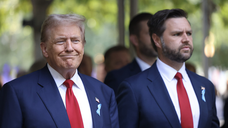 Donald Trump sorride mentre sta accanto a JD Vance