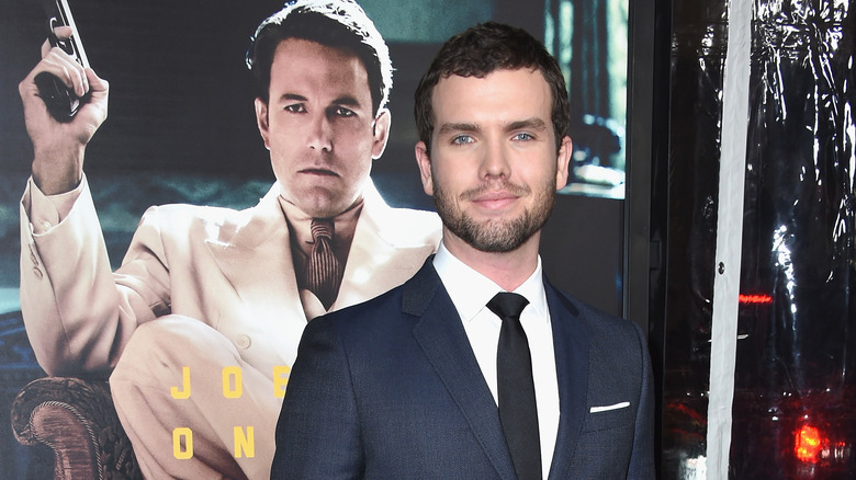 Austin Swift posa davanti a un poster con sopra Ben Affleck