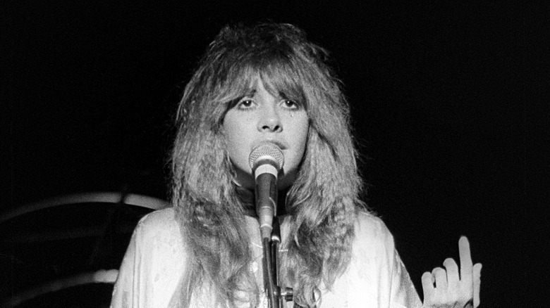 Stevie Nicks indossa uno scialle bianco mentre canta