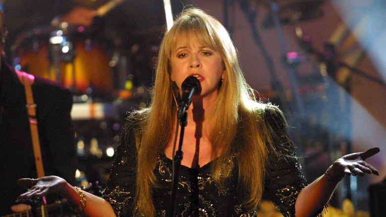 Stevie Nicks indossa un abito di pizzo nero e oro con braccialetti dorati