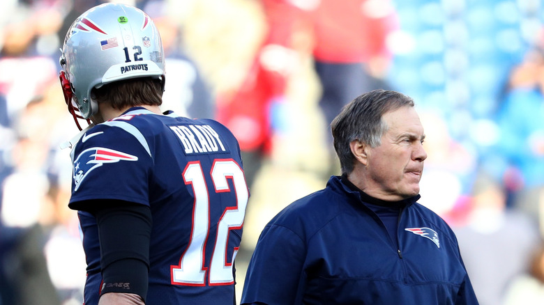 Tom Brady e Bill Belichick stanno fianco a fianco sul campo di football