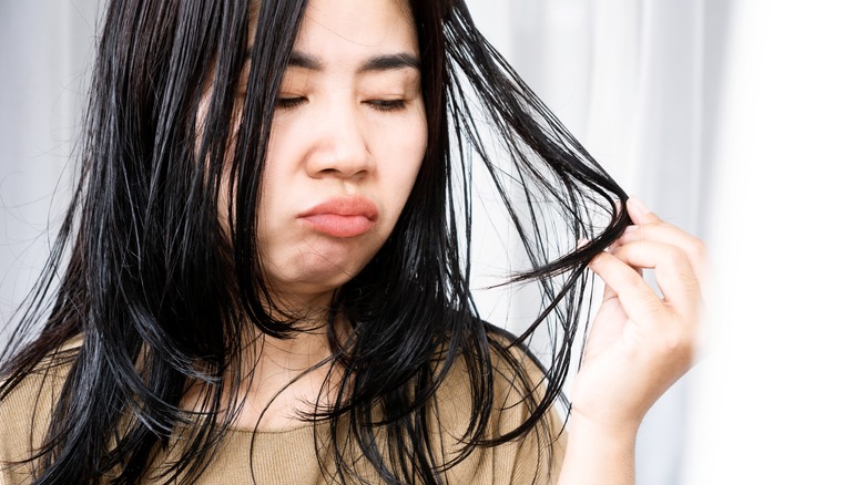 Donna che acciglia i capelli grassi