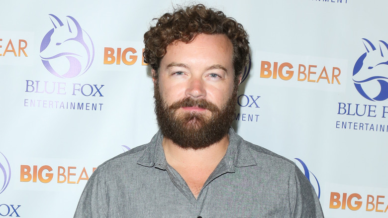 Danny Masterson posa per i fotografi mentre indossa una camicia con colletto grigio